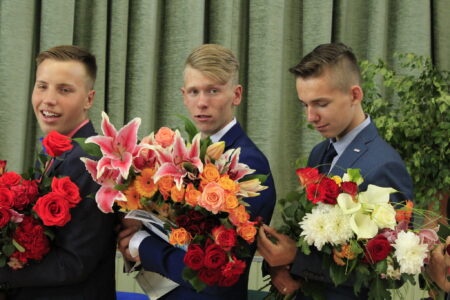 Three Groomsmen Holding Flower Bouquets